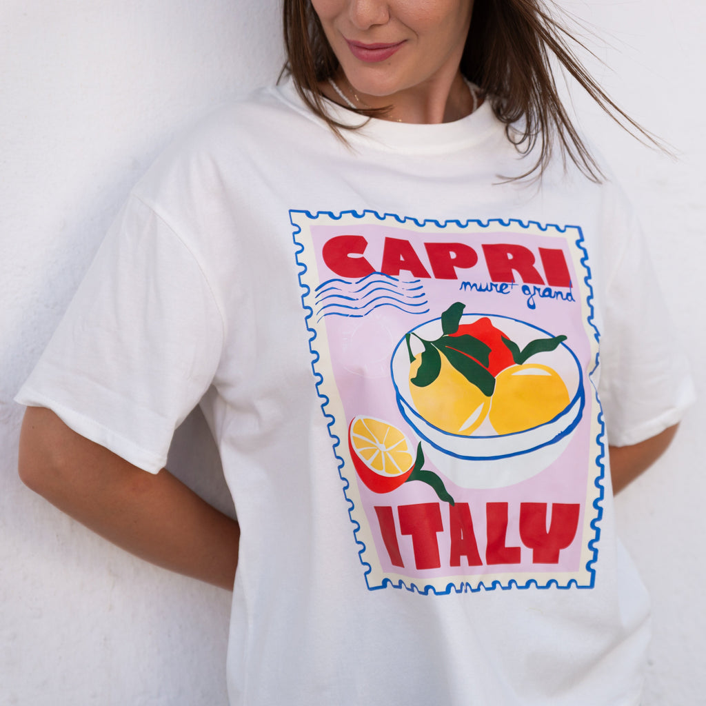 Person wearing a white t-shirt with a 'Capri Italy' graphic design.